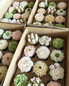 two boxes filled with cupcakes covered in flowers