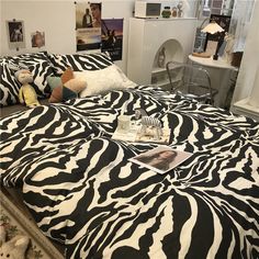 a zebra print bedspread on a bed in a room with pictures and stuffed animals