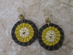 What's brown, yellow, and tan, and groovy all over? Iraca. Fiber. Earrings. With a seed bead nonetheless. Iraca fiber - The discs are hand woven, and no two are exactly the same. Source: Fallen leaves from Iraca palm plants in South America. Color: Brown, yellow, and tan Iraca disc diameter: 1.4 inches (35.56 mm) Earring length: 2 inches (50.8 mm) Ear wire: 14k gold-filled Handmade Yellow Circle Earrings, Yellow Round Earrings For Beach, Bohemian Yellow Round Earrings, Yellow Bohemian Round Earrings, Yellow Earrings For Beach With Pierced Ears, Unique Yellow Summer Earrings, Unique Yellow Earrings For Summer, Yellow Earrings With Ear Wire For Beach, Yellow Earrings For Beach With Ear Wire