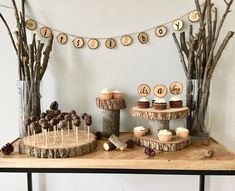 a table with cupcakes and desserts on it in front of some trees