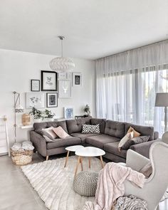 a living room with gray couches and pictures on the wall above them, along with a rug