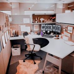 an office cubicle with desk, chair and pictures on the wall