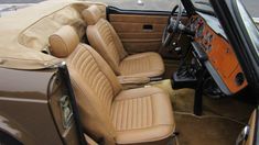 the interior of an old car with tan leather seats and beige cloth dash covers on it