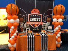 an orange and white balloon arch with basketballs on it at a sports themed birthday party