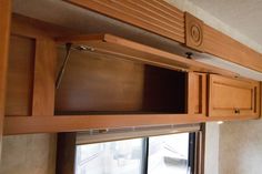 the inside of a camper with wooden cabinets and sliding glass doors