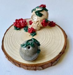 a small ceramic object sitting on top of a piece of wood next to a flower pot