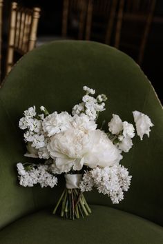 a bouquet of white flowers sitting on top of a green chair