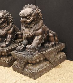 two bronze foo foo statues sitting next to each other