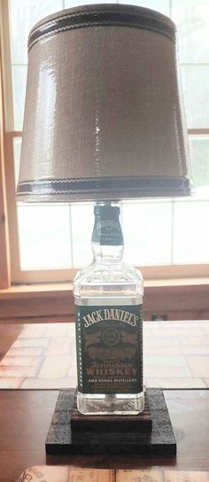 a lamp that is sitting on top of a wooden table next to a bottle of jack daniels