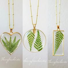 three different necklaces with green leaves in the shape of heart shaped pendants on gold chains