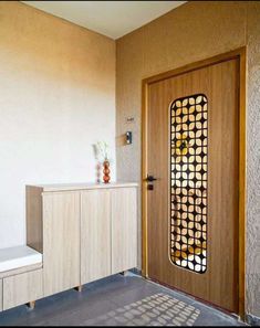 an entryway with a wooden door and decorative screen on the sideboard next to it