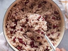 rice and beans are mixed together in a pot with a ladle on the side