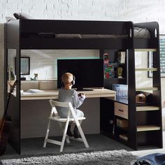 a child sitting at a desk in front of a loft bed