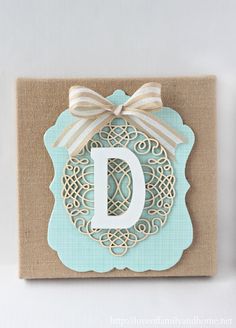 a card with the letter d on it and a bow hanging from it's side