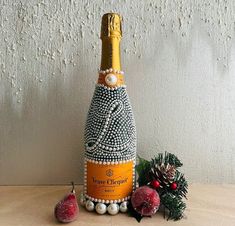 a wine bottle decorated with pearls and beads next to some christmas decorations on a table