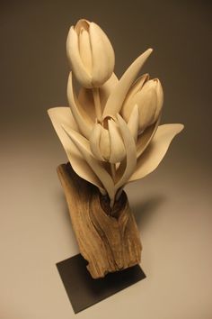 a sculpture made out of wood with white flowers