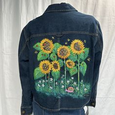 a denim jacket with sunflowers painted on it