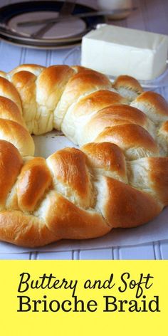 a braided bread on a plate with butter and soft brioche in the background