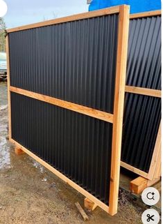 two large black and wood slats sitting on top of each other in the dirt