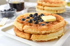 two waffles with blueberries and butter on a plate