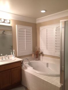 a bathroom with a large bathtub next to a walk in shower