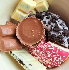 a bowl filled with lots of different types of chocolates and pastries on top of each other