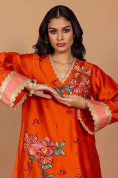 Sundown orange kurta with floral patchwork embroidery and scallop sleeves. Paired with embroidered pant.
Component: 2
Pattern: Embroidered
Type Of Work: Nakshi, triangle lace, sequin, cutdana, kisti stone, resham work
Neckline: V Neck
Sleeve Type: Scallop
Fabric: Chanderi Silk
Color: Orange
Other Details: 
Scallop detail
Patchwork embroidery
Occasion: Mehendi and Haldi - Aza Fashions Orange Resham Embroidery Sets For Spring, Orange Sets With Resham Embroidery For Spring, Spring Orange Resham Embroidery Sets, Spring Orange Sets With Resham Embroidery, Orange Floral Embroidered Sets, Traditional Orange Sets For Spring, Embroidered Orange Straight Kurta Set, Navratri Orange Long Sleeve Sets, Orange Long Sleeve Sets For Navratri