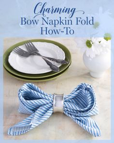 a blue and white striped bow napkin fold on top of a plate with silverware