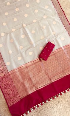 Gray Banarasi Katan Silk Saree with Motifs and Contrast Pink Zari Border| Traditional silk Beige saree | pattu saree| Bollywood Style A Banarasi saree is a robust canvas where a weaver's unmatched craftsmanship, imagination, and creativity comes to life! His dexterous hands beautifully blend the years of skills and experience to craft 6 yards of wearable art for the global woman of today's times. This saree is resplendent with all the elements of a rich Banarasi saree. The highlight of the drape is the color combination with zari work. The Motifs add a shimmering touch to the eye-catching shade making this saree a timeless classic. The zari drenched pallu and borders enveloped in zari add to the grandeur of this classic drape. *Note: This is a handwoven saree and there may be slight incons White Art Silk Dupatta With Border, White Banarasi Silk Dupatta With Border, White Paithani Silk Saree For Puja, White Tissue Silk Blouse With Zari Weaving, White Katan Silk Traditional Wear With Pallu, White Paithani Silk Saree With Zari Weaving, Dola Silk Traditional Wear With Border For Puja, Paithani Silk Traditional Wear With Border For Wedding, White Paithani Silk Dupatta For Puja