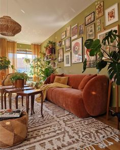 a living room filled with furniture and lots of pictures hanging on the wall above it