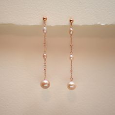 These delicate blush pink pearl earrings feature a soft pink pearl that dangles from the end of a cascade of smaller, rice-shaped pearls. The pearls are suspended from a fine rose gold filled chain with tiny 1.8 mm rose gold filled balls for a subtle touch of sparkle. The rose gold filled chain connects to a small 4 mm round gold-filled stud, creating a simple yet elegant look. Perfect for both special occasions and everyday wear, these earrings add a touch of charm to any outfit. ✶ P R O D U C Earrings Pearl Drop, Pink Pearl Earrings, Beads Craft Jewelry, Rose Gold Pearl, Beading Jewelery, Earrings Rose Gold, Rose Blush, Bridal Earrings Pearl, Gold Pearl Earrings