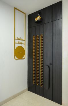 a black and gold door is next to a white wall