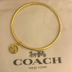 Nwot New Never Used. Coach Horse And Carriage Bangle Bracelet W Charm Coach Bangle Bracelet With Charm. Charm In Gold Over Brass! Comes In Black Unbranded Box. Perfect For The Coach Collector! Card And Dust Bag Is For Pic Purposes Only. Coach Adjustable Bangle, Adjustable Coach Bangle, Coach Bracelets As Gift, Adjustable Logo Charm Bracelet, Adjustable Yellow Gold Bracelet With Logo Charm, Adjustable Yellow Gold Jewelry With Logo Charm, Adjustable Jewelry With Logo Charm As Gift, Coach Metal Bangle Jewelry, Coach Gold Bangle Bracelet