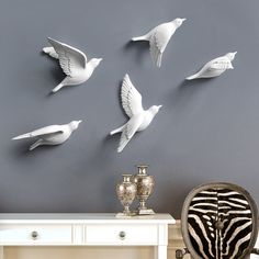 several white birds are flying in the air above a table and zebra print chair next to it