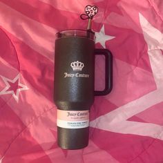 a travel mug with a flower sticking out of it on a pink and white flag