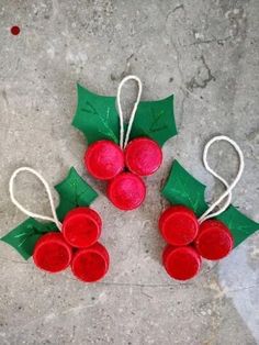 three red and green christmas decorations sitting on top of a cement floor next to each other