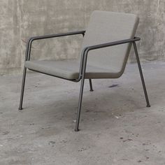 a gray chair sitting on top of a cement floor