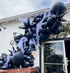 black balloons and spider webs are hanging from the side of a building