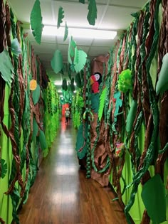 the hallway is decorated with paper machs and green leaves, while people are walking down the hall