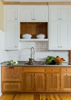 a kitchen with white cabinets and wooden floors