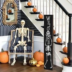 a skeleton sitting on a chair in front of a staircase decorated with pumpkins and decorations