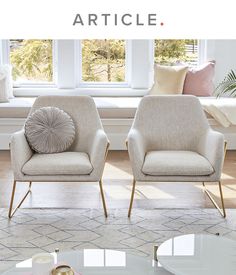 two chairs sitting next to each other on top of a rug in front of a window