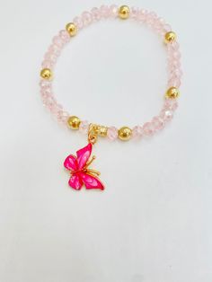 a pink bracelet with a gold butterfly charm