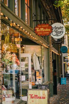 a store front with many different signs on the side of it's glass windows