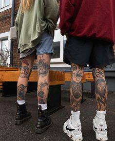 two people standing next to each other with tattoos on their legs and arms, both wearing roller skates