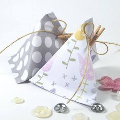 an origami shaped gift bag tied up with twine and some coins on the ground