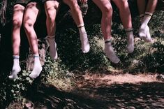 four people are hanging upside down in the air while wearing socks and socks on their feet