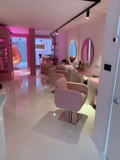 a room with chairs, mirrors and lights in it's pink hued walls