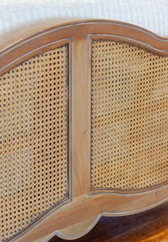 a close up of a wooden headboard with wicker panels on the top and bottom