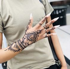 a woman's hand with hendix tattoos on her left arm and fingers